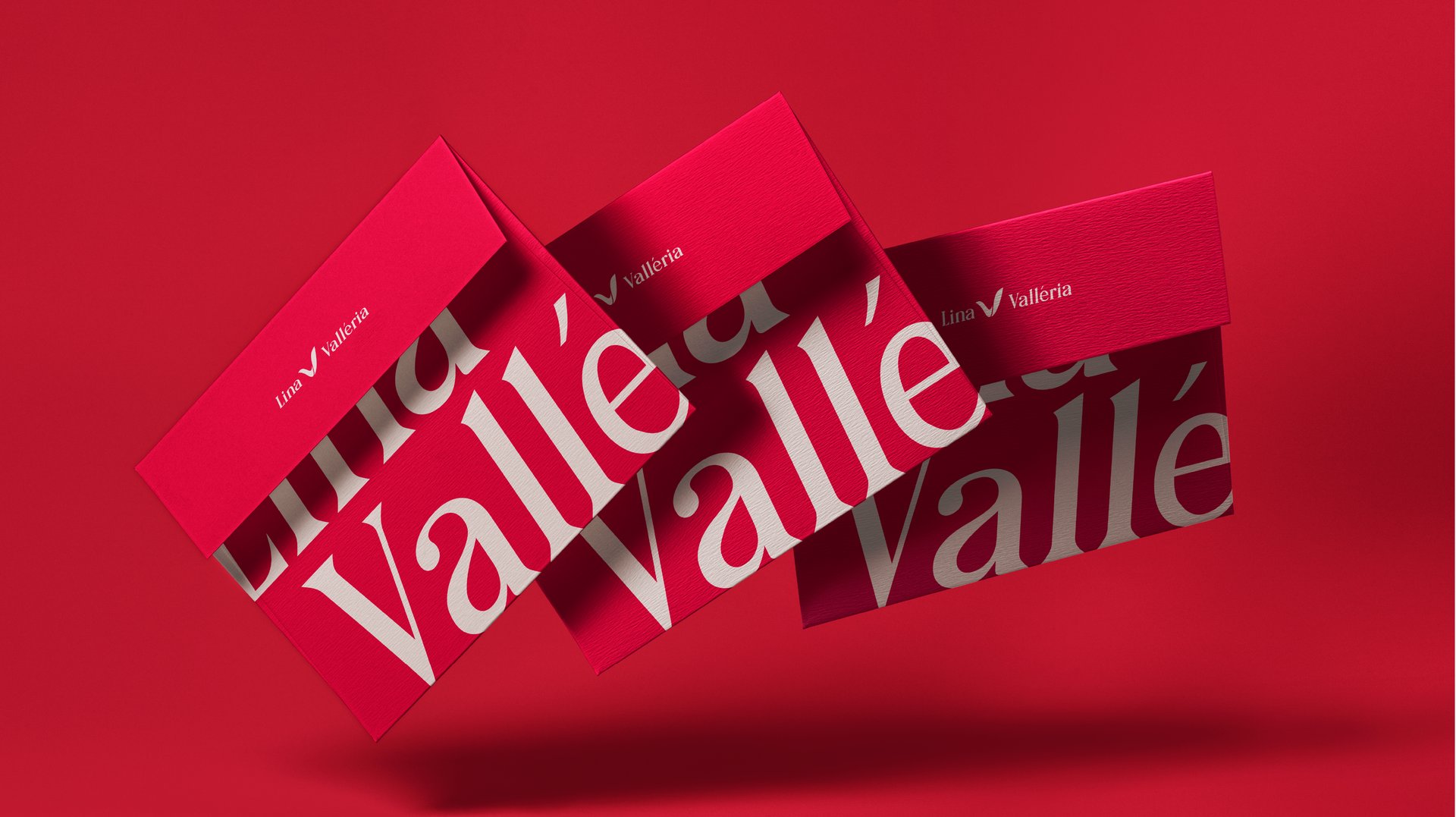 Aplicação da marca Lina Valléria em envelopes vermelhos com tipografia em destaque